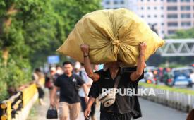 Pekerja informal berjalan di Kawasan Jalan Jenderal Sudirman, Jakarta, Rabu (6/8/2025). 