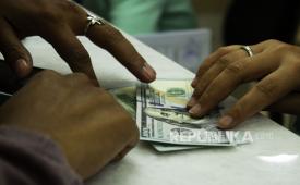 Teller melayani jual beli mata uang Dolar AS di sebuah tempat penukaran uang, Jakarta, Rabu (6/7/2022). Kurs Rupiah ditutup Rp14.999 per Dolar AS pada perdagangan Rabu (6/7) hari ini, melemah 0,03 persen ketimbang posisi penutupan perdagangan kemarin (5/7) pada Rp 14.994 per dolar AS. 