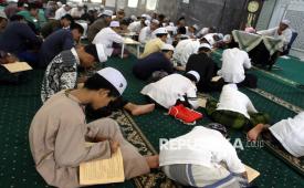 Santri menulis makna ayat yang dibacakan seorang ustaz di pondok pesantren di Kota Malang, Jawa Timur, Rabu (4/3/2026).  (ILUSTRASI)