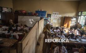 Sejumlah siswa kelas 3 dan 4 mengikuti kegiatan belajar mengajar di ruang kelas yang disekat akibat bangunan kelas ambruk di SD Negeri Tanggirejo, Tegowanu, Grobogan, Jawa Tengah, Selasa (21/7/2026).