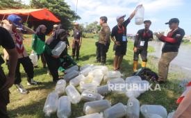 Sejumlah anggota komunitas pencinta lingkungan membawa benih ikan untuk ditebarkan di aliran Sungai Brantas, Kota Kediri, Jawa Timur, Sabtu (27/4/2024). 