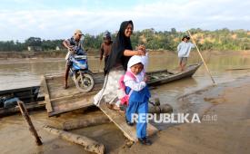Wali siswa mengantar pelajar ke sekolah dengan menggunakan perahu penyeberangan untuk melintasi sungai Lubuk Sidup, Aceh Tamiang, Aceh, Senin (12/1/2026). Pemerintah Kabupaten Aceh Tamiang menyebutkan sebanyak 71 sekolah telah memulai kembali aktivitas belajar mengajar pascabencana banjir bandang yang telah merusak 394 unit sarana pendidikan. 