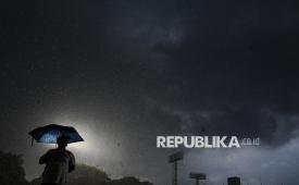 Seorang warga menggunakan payung saat hujan deras di Jakarta, Sabtu (15/11/2025). 