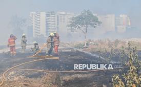 Petugas Suku Dinas Penanggulangan Kebakaran dan Penyelamatan (Sudin Gulkarmat) melakukan pendinginan lokasi kebakaran lahan alang-alang di kawasan Kampung Badan, Pademangan, Jakarta, Senin (14/9/2026). Sudin Gulkarmat mengerahkan 15 unit mobil dan 80 personel untuk memadamkan kebakaran yang terjadi pada pukul 12.55 WIB dan mengganggu perjalanan kereta api karena asap menutup jarak pandang masinis. 