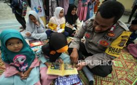 Anggota Bhabinkamtibmas Polsek Syamtalira Bayu mengajarkan anak membaca saat kegiatan Polisi Mengajar  di Desa Beurandang, Aceh Utara, Aceh, Rabu (15/6/2022).