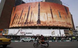 Warga Iran melewati papan iklan besar anti-Israel yang memuat gambar rudal Iran beberapa waktu lalu.