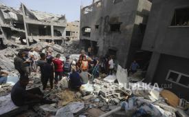 Warga Palestina melihat bangunan yang hancur di Kamp Pengungsian, Jalur Gaza, Ahad, 19 Mei, 2024. 