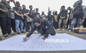 Salah seorang jurnalis yang tergabung dalam Koalisi Anti Pembungkaman Demokrasi menulis petisi saat melakukan aksi diam di Mapolda Jambi, Jambi, Rabu (17/9/2025). Aksi gabungan beberapa organisasi pers seperti Pewarta Foto Indonesia (PFI) Jambi, Aliansi Jurnalis Independen (AJI) Jambi, dan Ikatan Jurnalis Televisi Indonesia (IJTI) Jambi tersebut di antaranya menuntut dilakukannya proses hukum pada oknum polisi setempat yang diduga menghalang-halangi beberapa jurnalis saat melakukan peliputan dan meminta Kapolda Jambi meminta maaf secara terbuka atas kejadian tersebut. 