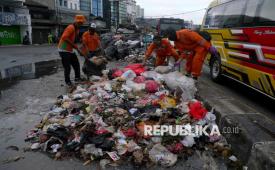Petugas kebersihan membersihkan sampah yang berserakan di jalan Ciputat, Tangerang Selatan, Banten, Selasa (16/12/2025). Tumpukan sampah di pinggir jalan Kawasan Ciputat dan Serpong, Tangerang Selatan, dikeluhkan warga lantaran tak kunjung diangkut. Tumpukan sampah ini menimbulkan bau menyengat. Jenis sampah yang menumpuk pun cukup beragam, mulai dari sampah rumah tangga hingga potongan kayu dan kasur. 