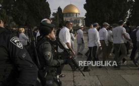 Polisi Israel mengawal pengunjung Yahudi yang menandai hari raya Paskah ke kompleks Masjid Al-Aqsa, yang dikenal umat Islam sebagai Tempat Suci Mulia dan bagi orang Yahudi sebagai Temple Mount, di Kota Tua Yerusalem selama bulan suci Ramadhan, Ahad (9/4/2023).