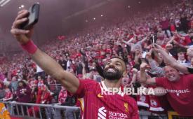 Pemain Liverpool Mohamed Salah merayakan gelar Liga Primer Inggris 2024/2025 bersama fans di Anfield, Ahad (27/4/2025). Liverpool memastikan keluar sebagai juara Liga Primer Inggris 2024/2025 setelah mengalahkan Tottenham Hotspur dengan skor 5-1. Tambahan poin dari kemenangan itu, membuat Liverpool unggul 15 poin dari peringkat kedua Arsenal. Arsenal tidak mungkin mengejar Liverpool karena liga tinggal menyisakan empat laga lagi. Liverpool saat ini menempati peringkat pertama klasemen Liga Inggris 2024-2025 dengan 82 poin, sementara Arsenal baru mengoleksi 67 poin. Gelar Liga Primer Inggris 2024/2025 menjadi gelar ke-20 bagi Liverpool.