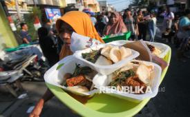 Warga membawa nampan berisi beraneka hidangan gratis yang didapat saat Lebaran Ketupat di Sukolilo Baru, Surabaya, Jawa Timur, Senin (7/4/2025). Tradisi yang dirayakan sepekan setelah Hari Raya Idul Fitri di kawasan pemukiman di Pantai Kenjeran itu digelar dengan membagikan berbagai hidangan secara gratis kepada warga sekitar dan sebagai ajang untuk bersilaturahim. 