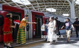 Petugas berpakaian adat daerah memberikan pin dan bendera kepada penumpang di Stasiun Kereta Cepat Whoosh Halim, Jakarta Timur, Senin (10/11/2025). Dalam rangka memperingati hari Pahlawan petugas PT Kereta Cepat Indonesia China (KCIC) mengenakan pakaian adat dari sejumlah daerah sebagai bentuk penghormatan kepada para pahlawan bangsa. 