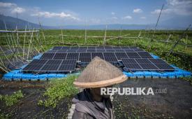 Petani berada di dekat panel surya yang terpasang di Pembangkit Listrik Tenaga Surya (PLTS) Terapung Rawa Pening, Desa Kesongo, Tuntang, Kabupaten Semarang, Jawa Tengah, Ahad (12/10/2025). 