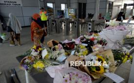Penumpang kereta rel listrik (KRL) melihat karangan bunga ucapan dukacita pascainsiden tabrakan antara KRL Commuterline dengan KA Argo Bromo Anggrek di Stasiun Bekasi Timur, Kota Bekasi, Jawa Barat, Kamis (30/4/2026). Sejumlah penumpang KRL meletakkan bunga di area tersebut sebagai ungkapan dukacita atas korban yang meninggal dalam peristiwa kecelakaan kereta Commuterline dengan KA Argo Bromo Anggrek.
