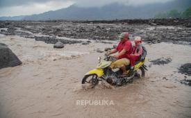 Warga melintasi aliran lahar hujan Gunung Semeru di Lumajang, Jawa Timur, Kamis (29/10/2026). Aktivitas warga di sekitar aliran sungai tersebut berlangsung di tengah imbauan kewaspadaan terhadap potensi banjir lahar hujan akibat meningkatnya curah hujan.