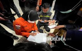 Seorang petugas penyelamat dari Badan Nasional Pencarian dan Pertolongan (Basarnas) mencatat nama-nama korban selamat dari kecelakaan kapal feri di sebuah pelabuhan di Banjarmasin, Kalimantan Selatan, Ahad (13/9/2026).