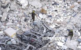 Tentara Israel mencari korban selamat di tengah reruntuhan bangunan tempat tinggal yang hancur akibat serangan rudal Iran di kota Bat Yam, Israel tengah, Ahad (15/6/2025).
