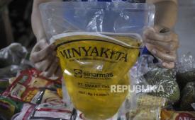 Pedagang menunjukkan minyak goreng kemasan rakyat MinyaKita yang dijual di kiosnya di Pasar Kosambi, Bandung, Jawa Barat, Kamis (7/12/2023). 