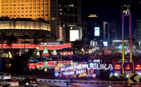 Warga menikmati suasana di sekitar aneka ornamen lampu hias dalam Jakarta Light Festival 2025 di kawasan Bundaran HI, Jakarta, Rabu (24/12/2025). Aneka ornamen lampu hias di sepanjang jalan protokol yang hadir mulai 23 hingga 27 Desember 2025 tersebut digelar dalam rangka memeriahkan perayaan Natal 2025 dan Tahun Baru 2026. Pengelola Plaza Indonesia dan Grand Indonesia menyatakan tidak berencana mengadakan pesta kembang api pada malam perayaan menyambut tahun baru 2026.