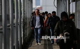 Pekerja belajan menuju halte Transjakarta, Jakarta, Senin (5/1/2026). Kondisi lalu lintas di sejumlah jalan di Jakarta seperti di Jalan Gatot Subroto, Pancoran dan Kuningan kembali dipadati sejumlah kendaraan pada Senin pagi usai libur Natal dan Tahun Baru 2026.