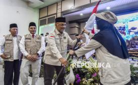 Menteri Haji dan Umrah (Menhaj) Mochamad Irfan Yusuf (kedua kanan) didampingi Wakil Gubernur Jambi Abdullah Sani (kiri) dan Kakanwil Kemenhaj Provinsi Jambi Wahyudi Abdul Wahab (kedua kiri) menerima bendera Merah Putih dari Petugas Penyelenggara Ibadah Haji (PPIH) Daerah saat penyambutan kepulangan jamaah haji Jambi di Embarkasi Haji Antara Provinsi Jambi, Jambi, Rabu (24/6/2026). Menhaj menerima kepulangan 444 orang haji asal Kota Jambi dan Kabupaten Muaro Jambi yang tergabung dalam kelompok terbang (kloter) BTH 20 di asrama haji setempat. 