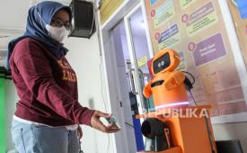 Pasien memindai Kartu Indonesia Sehat (KIS) ke robot Bytorium di Puskesmas Dinoyo, Malang, Jawa Timur, Kamis (24/10/2024). Teknologi robotik Artificial Intelegence (AI) tersebut dilengkapi dengan fitur komunikasi dua arah dan terintegrasi ke pusat data pasien sehingga memudahan dan mempersingkat waktu layanan laboratorium tes darah serta kolesterol. 