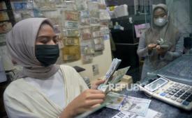 Karyawan menghitung uang di salah satu gerai penukaran uang asing di Jakarta, beberapa waktu lalu.