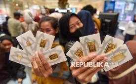 Pengunjung menunjukkan logam mulia Antam yang dibeli di Jakarta, Jumat (27/3/2026). Harga emas Antam mengalami penurunan sebesar Rp40 ribu per gram ke posisi Rp2.810.000 per gram pada Jumat (27/3) dibanding hari sebelumnya. 