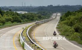 Pengendara motor melintas di proyek pembangunan Jalan Tol Jakarta-Cikampek II Selatan di Babakancikao, Kabupaten Purwakarta, Jawa Barat, Kamis (18/12/2025). PT Jasa Marga (Persero) Tbk menyatakan, progres konstruksi Jalan Tol Jakarta-Cikampek (Japek) II Selatan yang memiliki total panjang 62 kilometer dan menghubungkan Jalan Tol Lingkar Luar Jakarta (JORR) di Jatiasih, Bekasi dengan Tol Purbaleunyi di Sadang, Purwakarta telah mencapai 72,04 persen dan rencananya akan difungsionalkan saat arus mudik Lebaran 2026. 