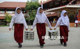 Pelajar membawa kotak berisi makan bergizi gratis (MBG) di SD Negeri Pejaten Barat 01, Jakarta, Selasa (4/8/2026). Menteri Keuangan Purbaya Yudhi Sadewa mengungkapkan realisasi anggaran MBG telah mencapai Rp101,1 triliun hingga akhir triwulan II 2026 dengan menjangkau sebanyak 63,13 juta penerima manfaat. Menurutnya, pelaksanaan program MBG menjadi salah satu faktor peningkatan belanja pemerintah pusat pada semester tahun ini. Sementara berdasarkan hasil putusan Mahkamah Konstitusi, mewajibkan anggaran program MBG dipisahkan dari anggaran pendidikan paling lambat pada APBN 2028.