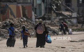Warga Palestina berjalan di tengah puing-puing bekas serangan Israel. Sebanyak 110 ribu orang terpaksa mengungsi dari Kota Rafah di Jalur Gaza selatan.