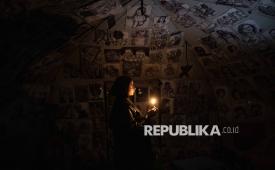 Marah Al-Za anin (18), seorang pengungsi Palestina, berdiri di dalam tendanya menyalakan lilin karena pemadaman listrik di Jalur Gaza utara, Gaza, Kamis (29/1/2026)/