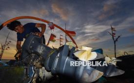 Nelayan membersihkan mesin kapalnya di Kampung Nelayan Merah Putih.