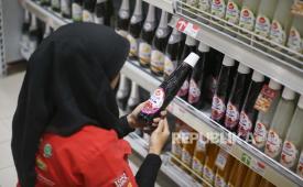 Petugas merapikan minuman bergula dalam kemasan di salah satu pusat perbelanjaan.