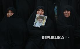 Warga Iran memeluk foto  Ayatollah Ali Khamenei saat berkumpul di Lapangan Enqelab, Teheran, Iran, Ahad (1/3/2026), untuk mengekspresikan duka cita atas tewasnya Pemimpin Tertinggi Iran itu. Khamenei tewas dalam serangan udara militer gabungan Amerika Serikat dan Israel pada Sabtu (28/2).