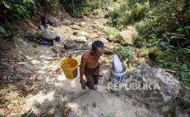 Warga mengambil air di mata air sungai yang mengering di Kabupaten Bogor, Jawa Barat. Pemkab Bogor mengirimkan air bersih ke wilayah barat dan timur yang alami kekeringan.