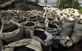 Warga melintas di dekat tumpukan karung yang berisi batu bara di kawasan Sungai Serut, Kecamatan Muara Bangka Hulu, Kota Bengkulu, Provinsi Bengkulu, Sabtu (06/5/2023). 