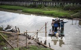 Sejumlah warga menyeberangi Sungai Beringin menggunakan rakit buatan di Mangkang Wetan, Tugu, Semarang, Jawa Tengah, Jumat (30/1/2026). Sejumlah warga setempat berharap Pemkot Semarang segera menindaklanjuti perbaikan jembatan, setelah selama sekitar dua pekan mereka terpaksa menyeberangi Sungai Beringin menggunakan rakit buatan swadaya masyarakat akibat jembatan penghubung ke Kampung Tambaksari ambrol diterjang banjir pada Kamis (15/1). 