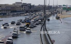 Kendaraan melewati genangan air banjir akibat hujan lebat di Dubai, Uni Emirat Arab, Kamis, (18/4/2024).