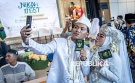 Pasangan pengantin menunjukkan buku nikah usai prosesi nikah massal pada Nikah Fest 2026 di Jakarta, Sabtu (27/6/2026). Kementerian Agama (Kemenag) menggelar program nikah massal yang diikuti 30 pasangan dari berbagai daerah di Indonesia sebagai upaya memberikan legalitas pernikahan yang sah sekaligus mendukung kemandirian ekonomi keluarga melalui pemberian bantuan modal usaha. 