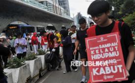 Relawan yang tergabung dari komunitas Operasi Semut memungut sampah saat Hari Bebas Kendaraan Bermotor (HBKB) di kawasan Bundaran HI, Jakarta, Ahad (19/1/2025). 