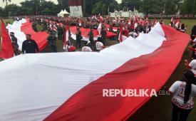 Sejumlah personel TNI dan Polri membentangkan Bendera Merah Putih dalam Kirab Merah Putih di Lingkar Stadion Pakansari, Kabupaten Bogor, Jawa Barat, Kamis (14/8/2025). Pemerintah Kabupaten Bogor menggelar Kirab Bendera Merah Putih sepanjang 600 meter untuk menyambut HUT ke-80 Kemerdekaan Republik Indonesia. 