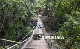 Warga menyeberangi Jembatan Pongpet yang nyaris ambruk di Desa Margacinta, Kecamatan Cijulang, Kabupaten Pangandaran, Jawa Barat, Senin (14/9/2026). Jembatan gantung sepanjang 64 meter yang menghubungkan Dusun Cidawung dan Dusun Margajaya tersebut dibangun pada 1992 dan kini dibangun kembali oleh TNI untuk mempermudah mobilitas warga, membuka akses wilayah terisolasi, serta memperlancar kegiatan ekonomi dan pendidikan. 