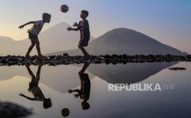 Dua anak bermain bola di pesisir pantai di Kelurahan Kalumata, Kota Ternate, Maluku Utara, Ahad (5/11/2023). BMKG melatih warga Ternate untuk mengantisipasi potensi tsunami.