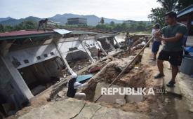 Warga menyelamatkan bagian bangunan Taman Pendidikan Al-Quran di kawasan Masjid Jamaatul Yaqin Banda Cino, Talao Mundam, Nagari Katapiang, Padang Pariaman, Sumatera Barat, Ahad (4/1/2026). Masyarakat setempat bergotong-royong menyelamatkan bagian bangunan dan isinya yang masih bisa dimanfaatkam setelah bangunan itu ambruk ke sungai Batang Anai pascabanjir bandang susulan pada Sabtu (3/1/2026). 