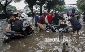 Warga membantu pengendara sepeda motor yang mogok saat menerobos banjir di Jalan Daan Mogot, Jakarta, Kamis (22/1/2026). Banjir setinggi 50-60 cm akibat hujan berintensitas tinggi serta buruknya sistem drainase tersebut membuat sejumlah kendaraan mogok dan lalu lintas terganggu. 
