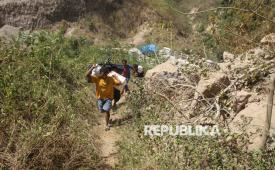 Sejumlah warga membawa bantuan menyusuri jalanan berbatu dari posko bantuan Desa Rokirole ke Desa Nitunglea, Pulau Palue, Kabupaten Sikka, NTT, Rabu (19/8/2026). Pulau berpenduduk sekitar 11.000 jiwa yang berjarak 20-30 dari pusat gempa bumi magnitudo 7,7 itu kesulitan mendistribusikan bantuan karena sejumlah jalan antardesa terputus akibat tanah longsor terdampak gempa.  