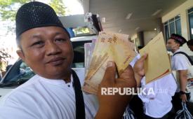 Calon haji memperlihatkan uang riyal hasil penukaran pada mobil kas keliling Bank Jatim di Kabupaten Kediri, Jawa Timur, Kamis (24/4/2025). Layanan penukaran uang tersebut dimanfaatkan jamaah calon haji yang membutuhkan uang riyal untuk transaksi keuangan di Tanah Suci. 