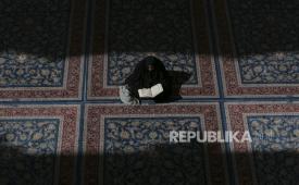 Seorang wanita berdoa dan membaca Alquran di tempat suci Imam Ali untuk menandai dimulainya bulan suci Ramadhan di Najaf, 160 kilometer (100 mil) selatan Baghdad, Irak, Ahad, 3 April 2022. Tersentuh Alquran, Perempuan Islandia Anti-Islam Ini Temukan Hidayah dan Jadi Mualaf